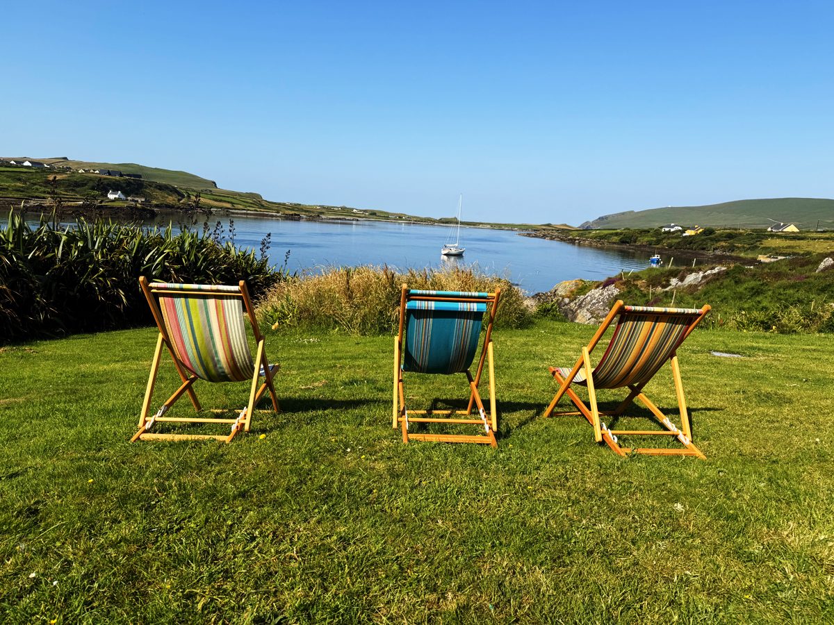 Three striped deckchairs on the lawn looking out over the harbour